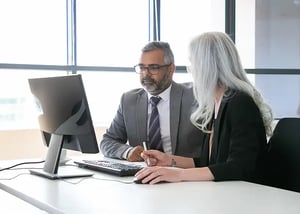 two-focused-colleagues-watching-discussing-content-computer-monitor